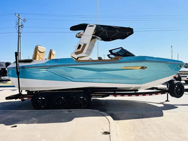 Slide: The Image of 2024 Nautique G25 Paragon boat in blue on a trailer, side view. - 5