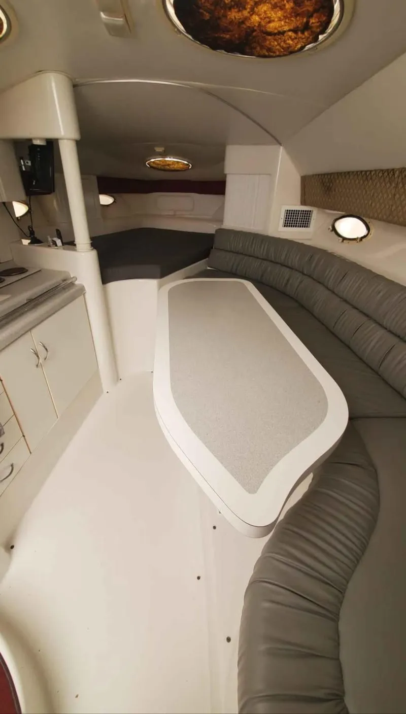Slide: The Image of Interior of a 1997 Chris-Craft 34 boat with a sleek dining area and modern design. - 13