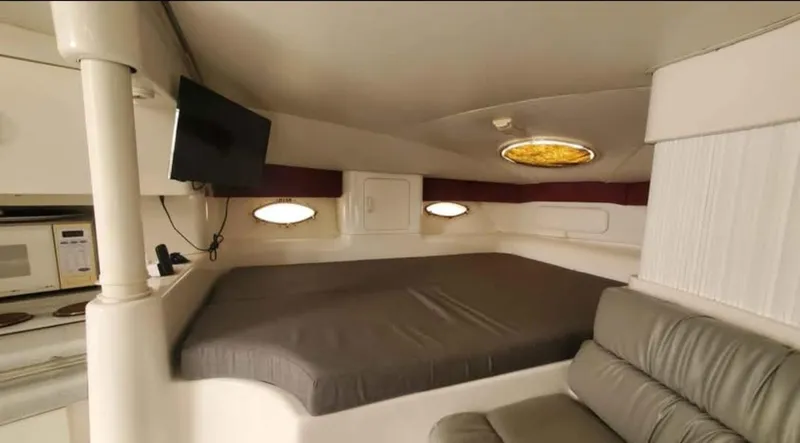 Slide: The Image of 1997 Chris-Craft 34 interior cabin with bed, TV, and seating area. - 14
