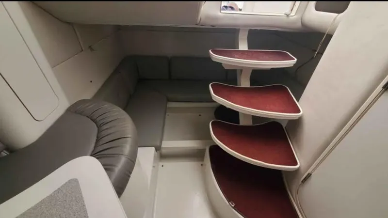 Slide: The Image of Interior of a 1997 Chris-Craft 34 boat with red-carpeted stairs and gray seating. - 17