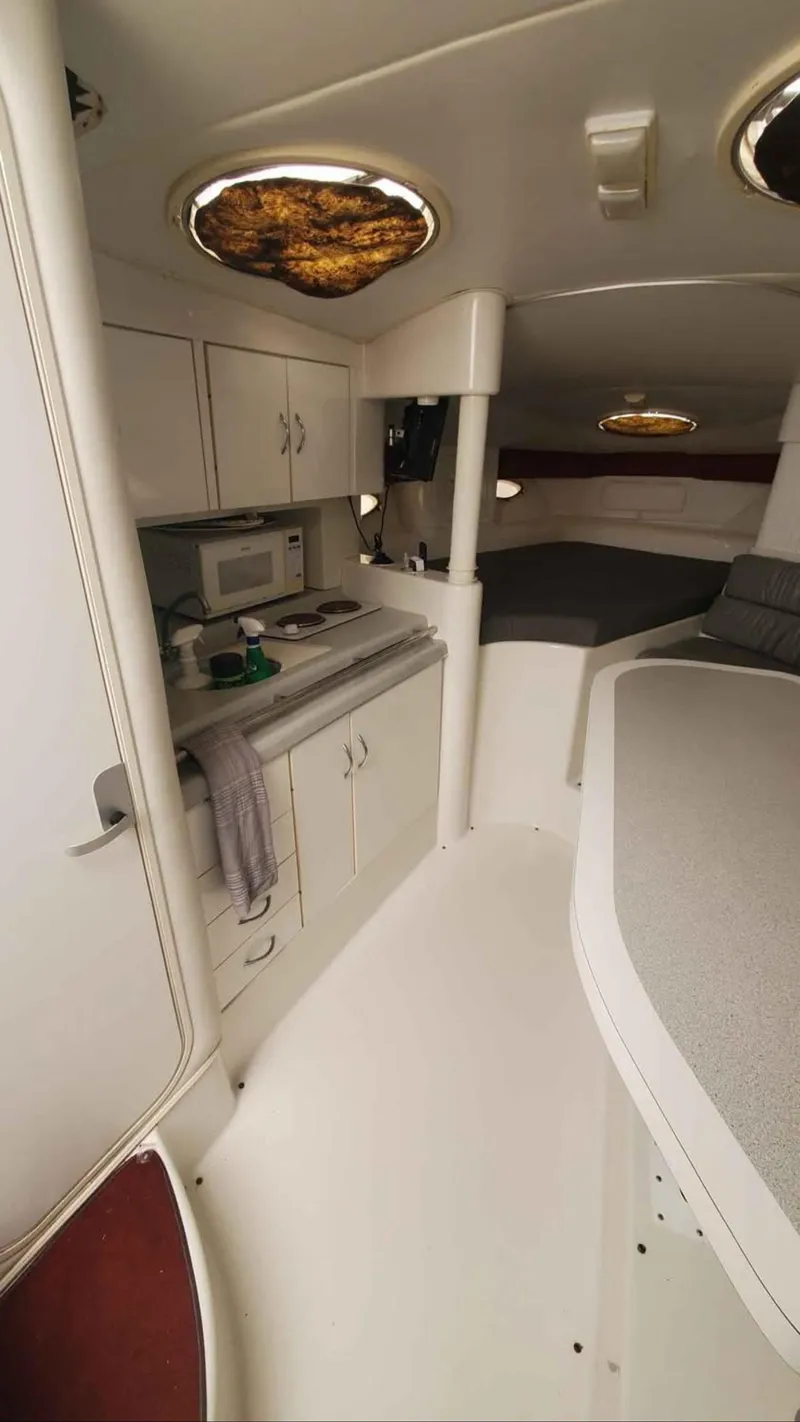 Slide: The Image of Interior of a 1997 Chris-Craft 34 boat with kitchenette and seating area. - 7