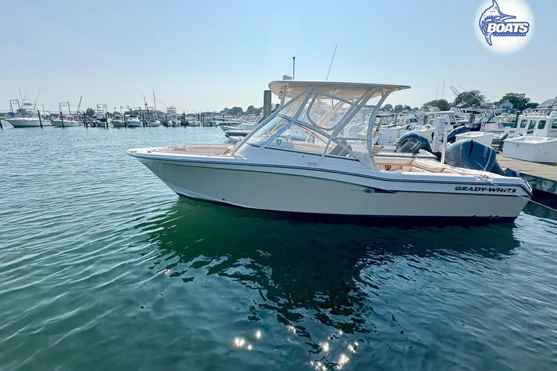 Slide: The Image of 2014 Grady-White Freedom 255 boat docked in a marina under clear skies. - 1