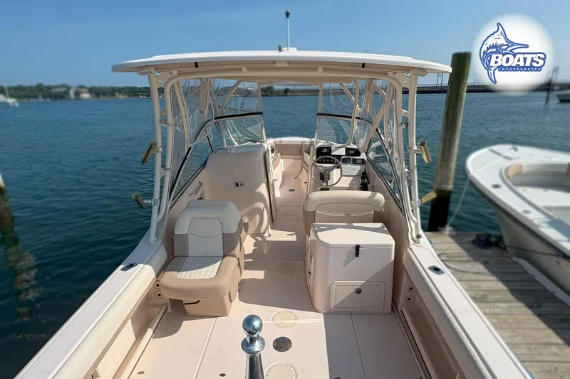 Slide: The Image of 2014 Grady-White Freedom 255 boat docked, featuring spacious seating and helm, on calm waters. - 10