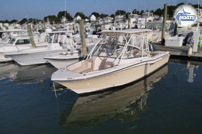 Slide: The Image of 2014 Grady-White Freedom 255 boat docked in a marina, surrounded by other vessels. - 2
