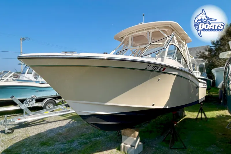Slide: The Image of A Grady-White Freedom 255 boat is on a lawn, surrounded by other boats. - 5