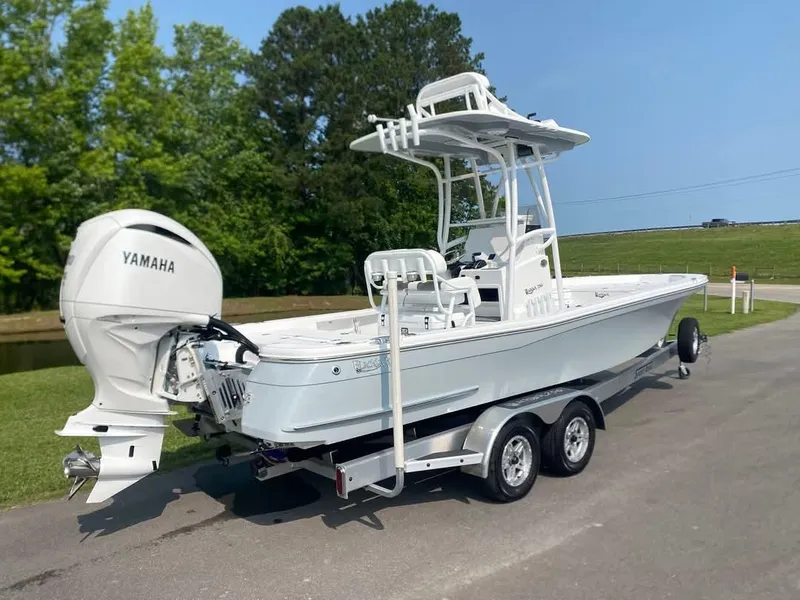 Slide: The Image of 2025 BlackJack 256 Bay boat with Yamaha engine on a trailer, parked outdoors. - 2