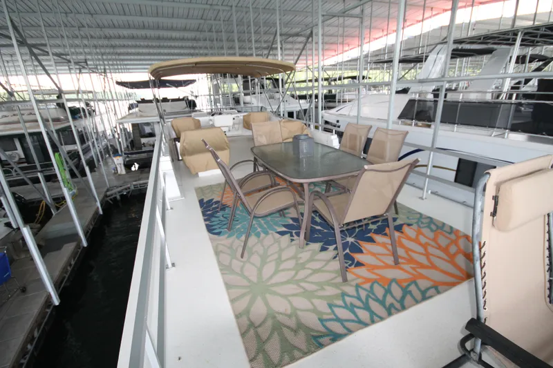 Slide: The Image of Outdoor seating area on 2011 Gibson 50 Cabin Yacht, featuring a table and chairs on a colorful rug. - 12