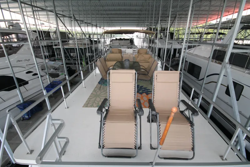 Slide: The Image of 2011 Gibson 50 Cabin Yacht with deck chairs and seating area in a marina. - 15