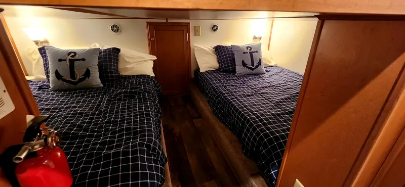 Slide: The Image of Cozy cabin bedroom in 2011 Gibson 50 Yacht with nautical-themed bedding and anchor pillows. - 27
