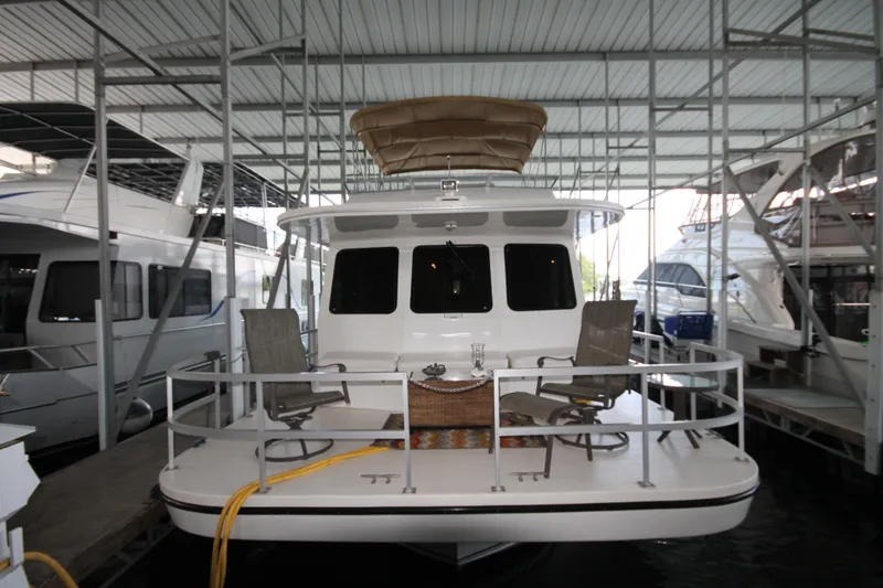 Slide: The Image of 2011 Gibson 50 Cabin Yacht docked, featuring spacious deck with chairs under covered marina. - 3