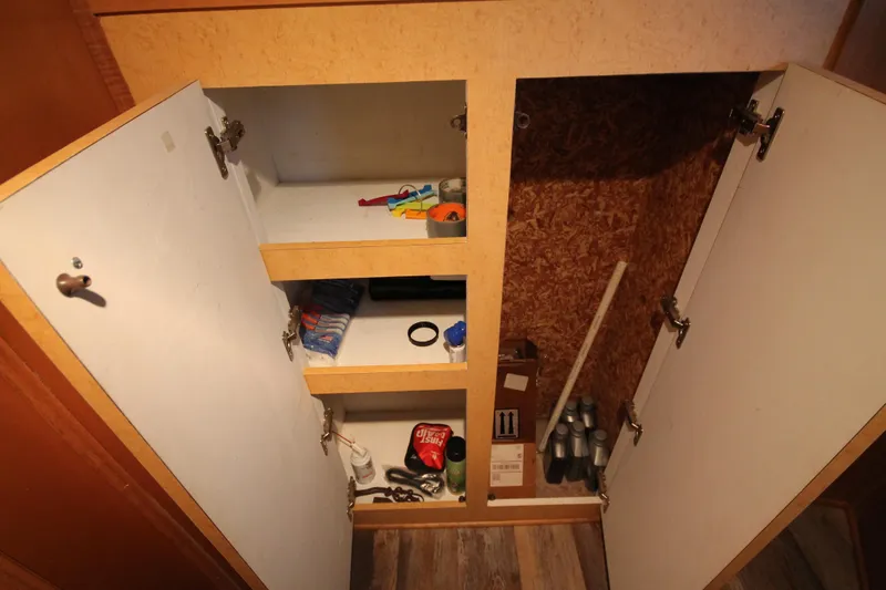Slide: The Image of Open cabinet on 2011 Gibson 50 Cabin Yacht, showing shelves with various items. - 32