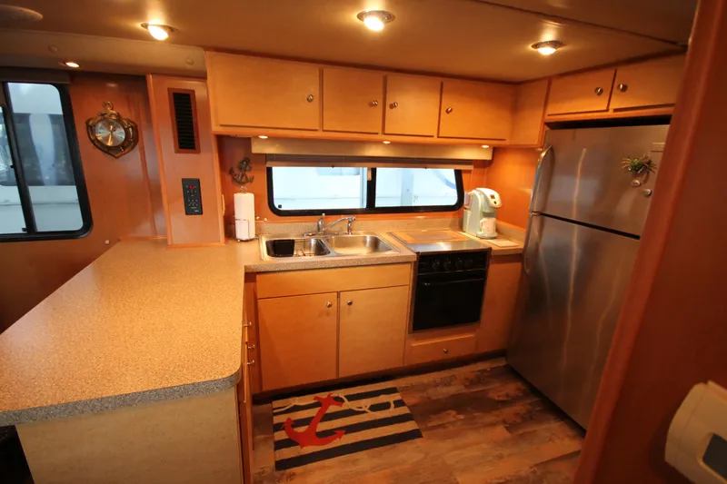 Slide: The Image of Modern kitchen in 2011 Gibson 50 Cabin Yacht with wood cabinets and stainless steel appliances. - 48