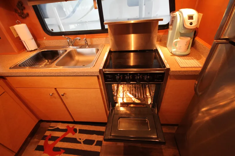 Slide: The Image of Kitchen area of 2011 Gibson 50 Cabin Yacht with stove, sink, and coffee maker. - 50