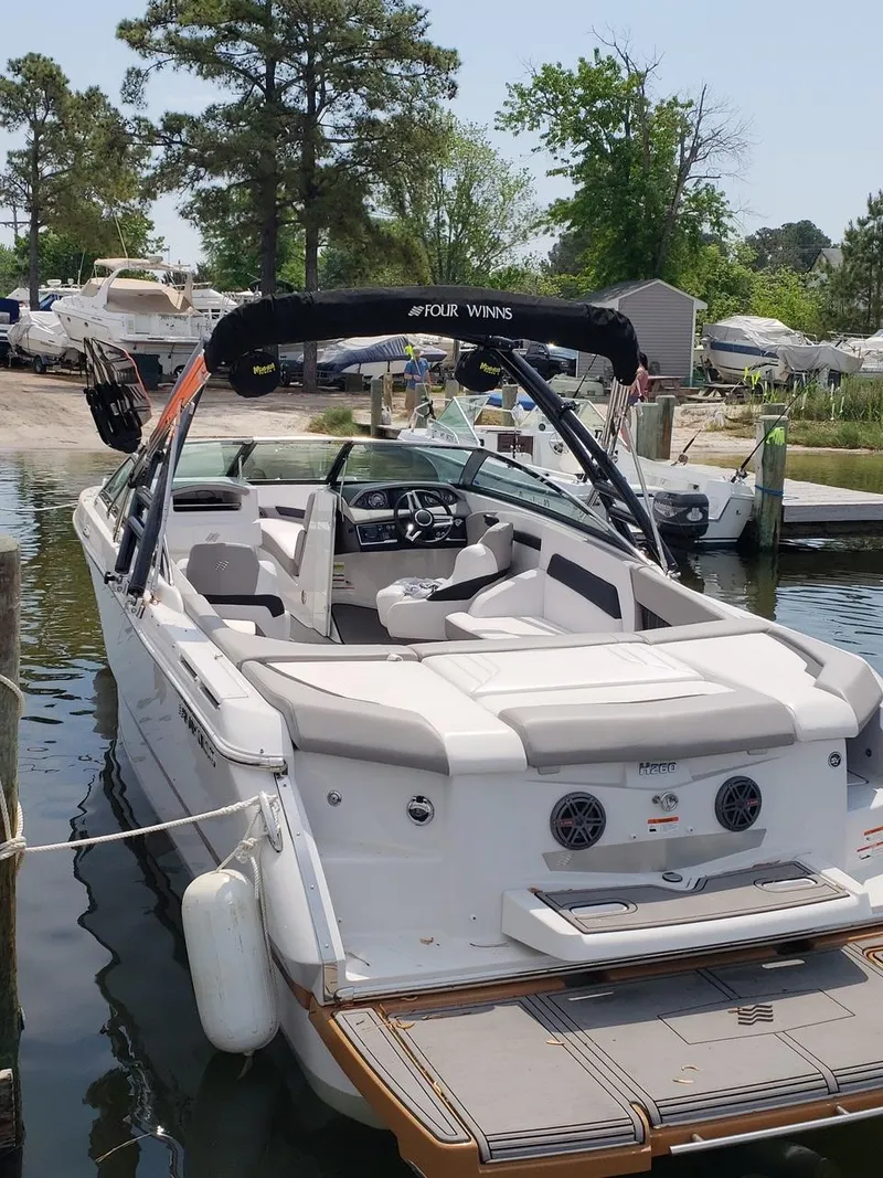 Slide: The Image of 2017 Four Winns H260 boat docked, featuring spacious seating and sleek design. - 3
