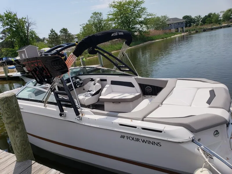 Slide: The Image of 2017 Four Winns H260 boat docked on a calm lake, featuring sleek design and comfortable seating. - 5