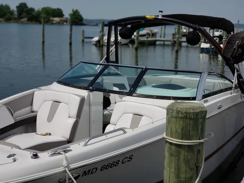 Slide: The Image of 2017 Four Winns H260 boat docked by a serene lake. - 6