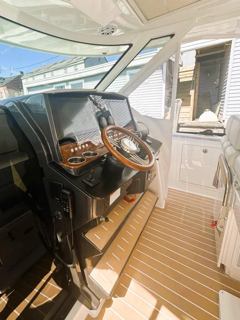 Slide: The Image of 2024 Tiara Yachts 43 LS helm with wooden steering wheel and modern controls. - 13