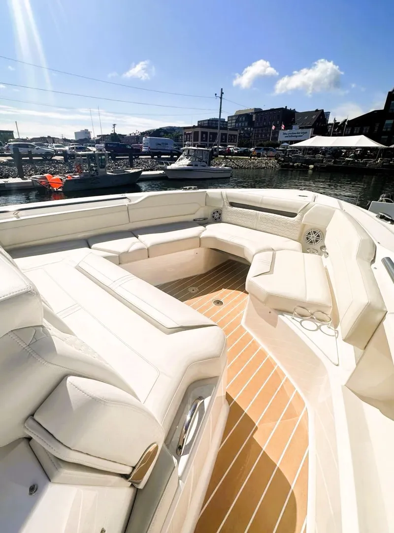 Slide: The Image of 2024 Tiara Yachts 43 LS with luxurious seating, docked at a marina under a clear sky. - 18