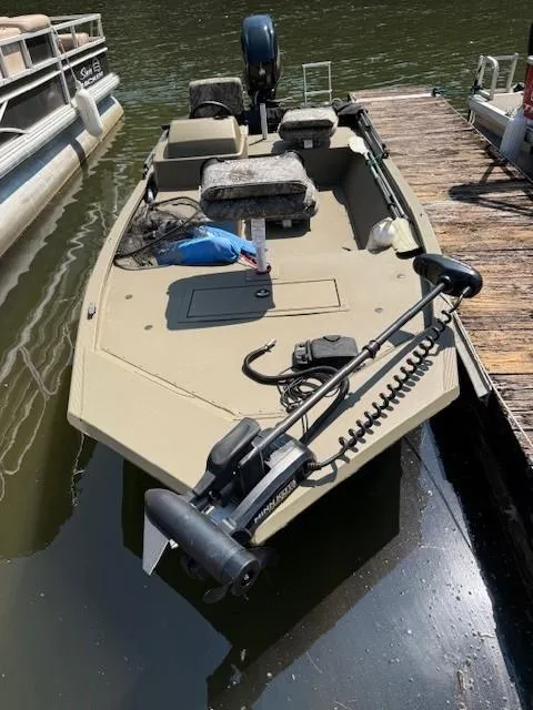 The Image of 2024 Tracker Grizzly 1648 SC boat docked on calm water. - 1