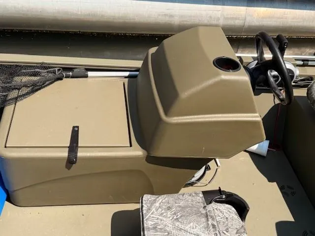 Slide: The Image of 2024 Tracker Grizzly 1648 SC boat console with steering wheel and storage compartment. - 6