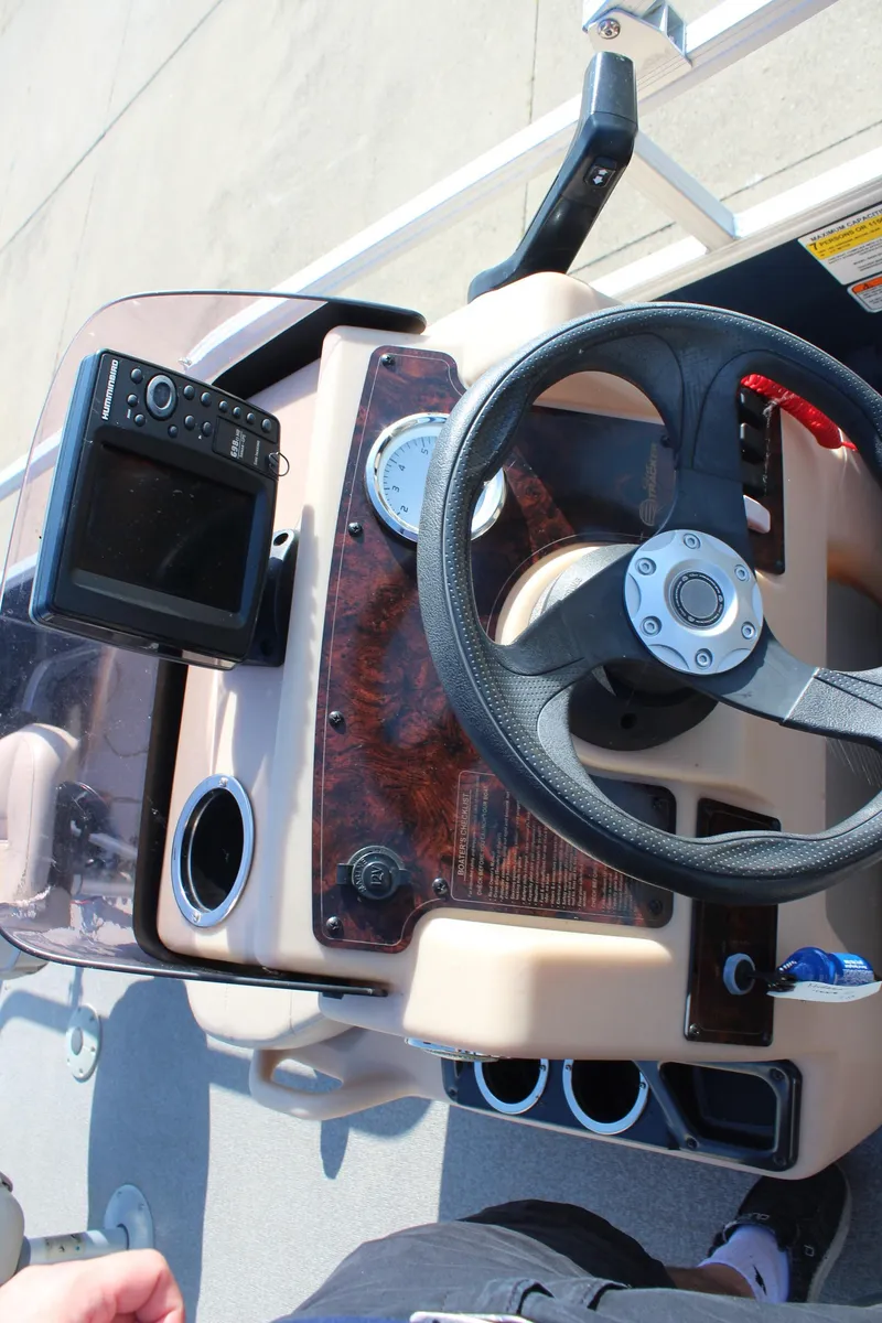 Slide: The Image of 2019 Sun Tracker Bass Buggy 16 XL Select dashboard with steering wheel and control panel. - 16