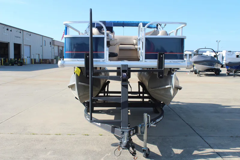 Slide: The Image of 2019 Sun Tracker Bass Buggy 16 XL Select pontoon boat on trailer in a marina. - 2