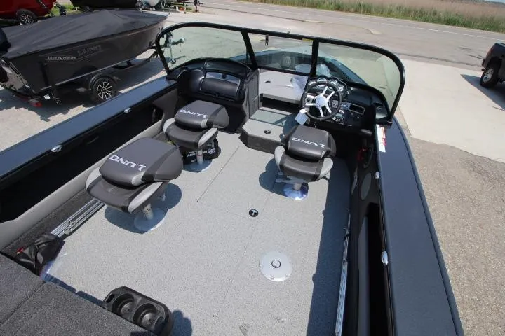 Slide: The Image of 2025 Lund 1875 Crossover XS boat interior with seating and steering console. - 2