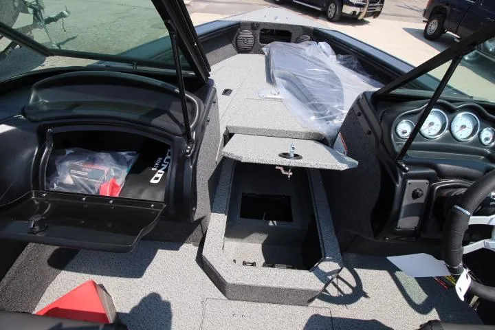 Slide: The Image of 2025 Lund 1875 Crossover XS boat interior with open storage compartments and dashboard. - 3