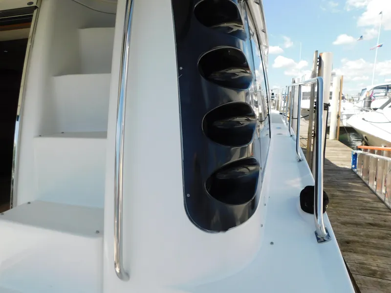 Slide: The Image of 2002 Carver 450 Voyager Pilothouse yacht docked, showcasing sleek design and polished railings. - 11