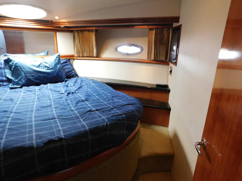 Slide: The Image of Luxurious bedroom in 2002 Carver 450 Voyager Pilothouse yacht with blue bedding and wood accents. - 24