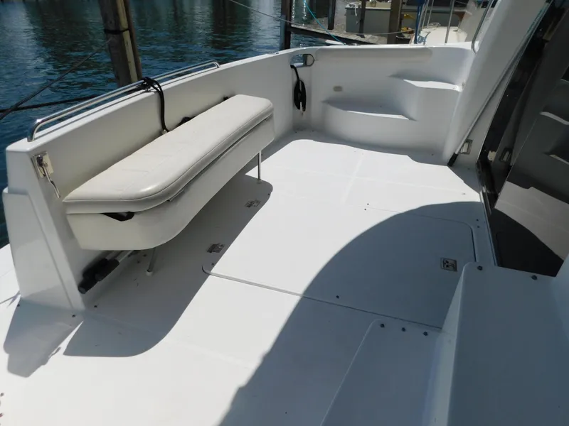 Slide: The Image of 2002 Carver 450 Voyager Pilothouse deck with seating, docked by the water. - 7