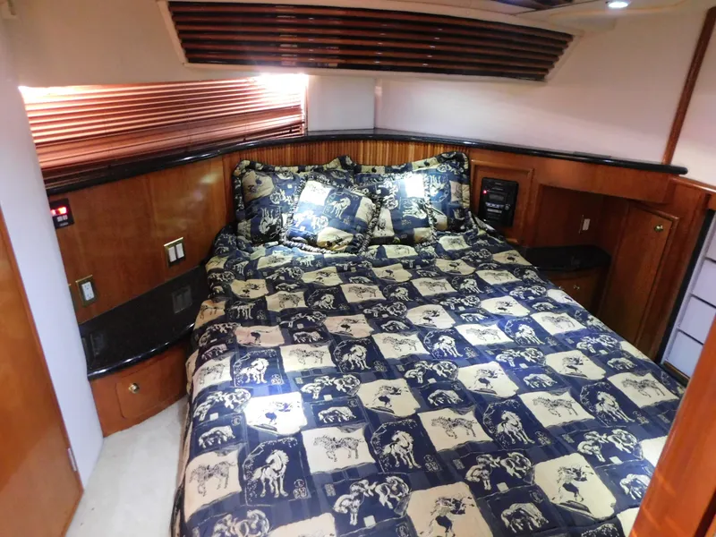 Slide: The Image of Luxurious bedroom interior of 2002 Carver 450 Voyager Pilothouse yacht with patterned bedding. - 25