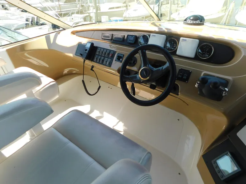 Slide: The Image of Interior of 2002 Carver 450 Voyager Pilothouse, featuring helm controls and seating. - 31
