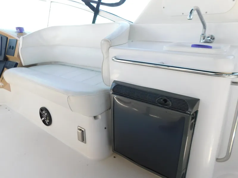 Slide: The Image of 2002 Carver 450 Voyager Pilothouse interior with seating, sink, and mini fridge. - 34