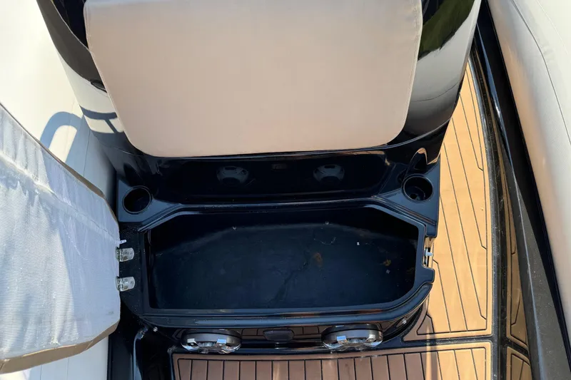 Slide: The Image of 2019 Brig Eagle 650 boat storage compartment with cushioned seating and wooden deck. - 10