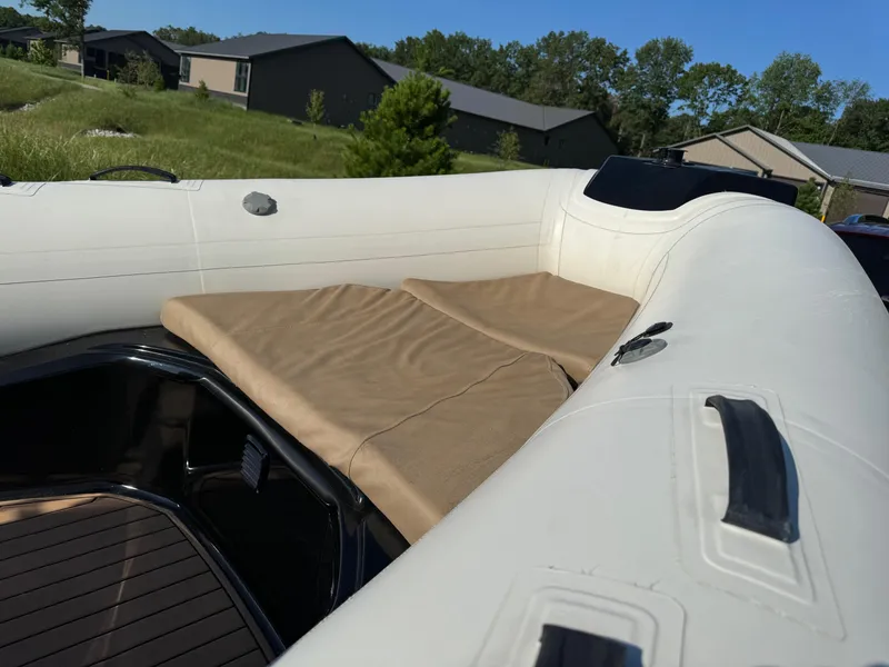 Slide: The Image of 2019 Brig Eagle 650 boat with cushioned seating, set against a suburban backdrop. - 11