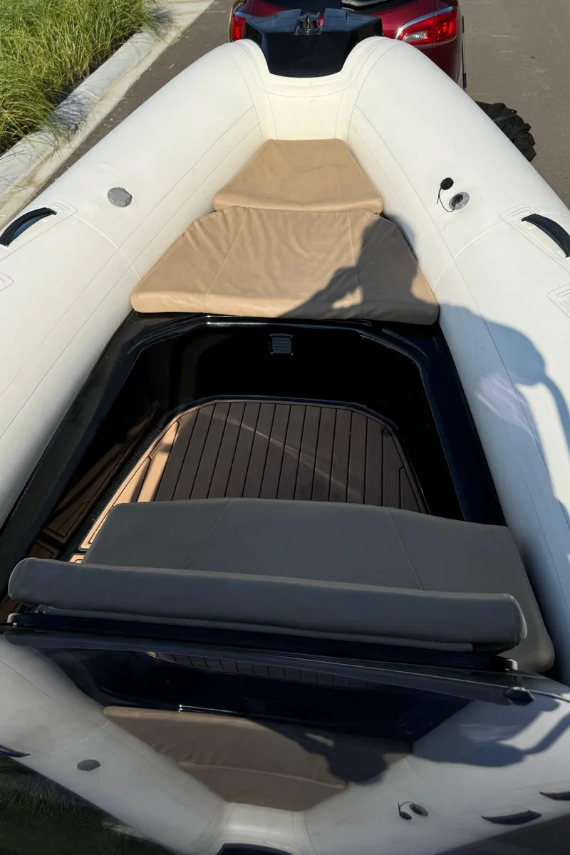 Slide: The Image of 2019 Brig Eagle 650 inflatable boat with beige seating and deck, parked on a trailer. - 13
