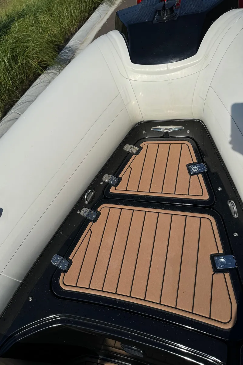 Slide: The Image of 2019 Brig Eagle 650 boat interior with cushioned seating and wooden deck. - 16