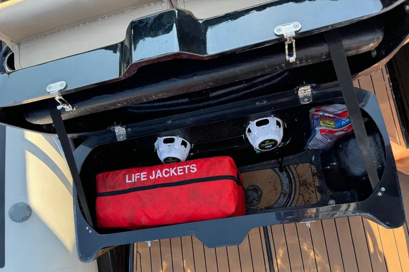 Slide: The Image of Open storage compartment on 2019 Brig Eagle 650 with life jackets and equipment. - 23