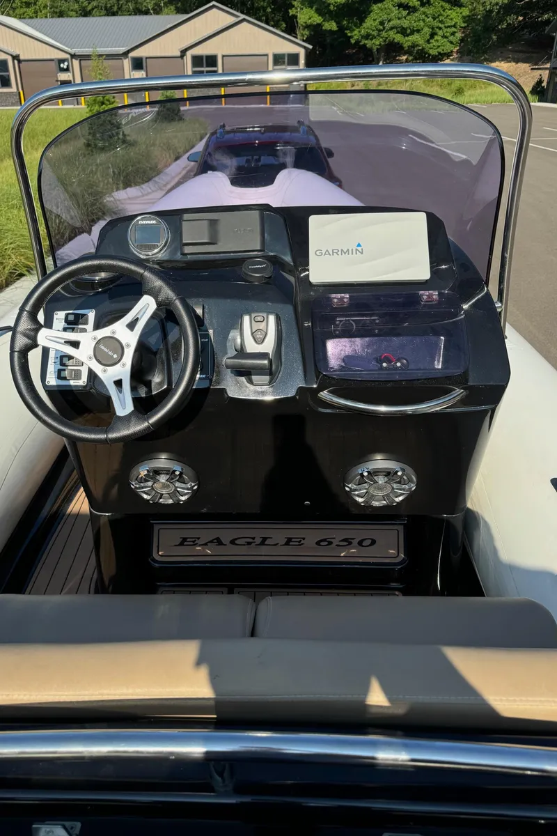Slide: The Image of 2019 Brig Eagle 650 boat dashboard with steering wheel and navigation equipment. - 29