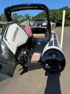 Slide: The Image of 2019 Brig Eagle 650 boat with Evinrude engine and American flag, parked outdoors. - 46
