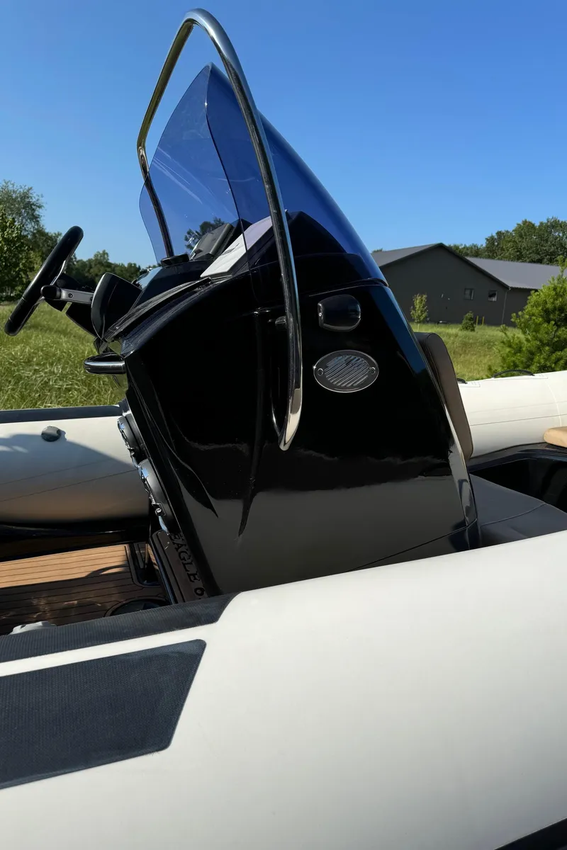 Slide: The Image of 2019 Brig Eagle 650 boat console with windshield, steering wheel, and outdoor setting. - 7