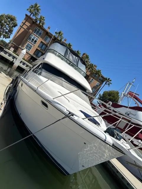 Slide: The Image of 2002 Bayliner 3988 Command Bridge Motoryacht docked at marina under clear blue sky. - 1