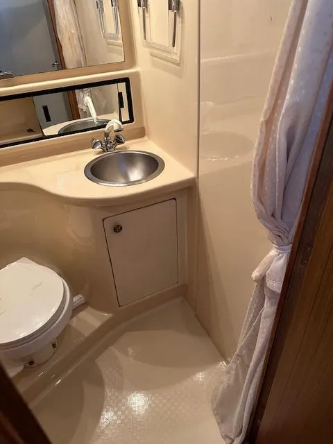Slide: The Image of 2002 Bayliner 3988 Command Bridge Motoryacht bathroom with sink, toilet, and shower curtain. - 10