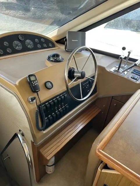 Slide: The Image of 2002 Bayliner 3988 Command Bridge Motoryacht helm with steering wheel and control panel. - 13