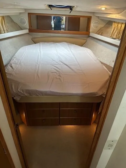 Slide: The Image of 2002 Bayliner 3988 Command Bridge Motoryacht bedroom with spacious bed and wooden cabinetry. - 21