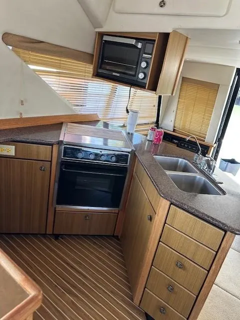 Slide: The Image of Interior of 2002 Bayliner 3988 Command Bridge Motoryacht kitchen with stove and sink. - 23