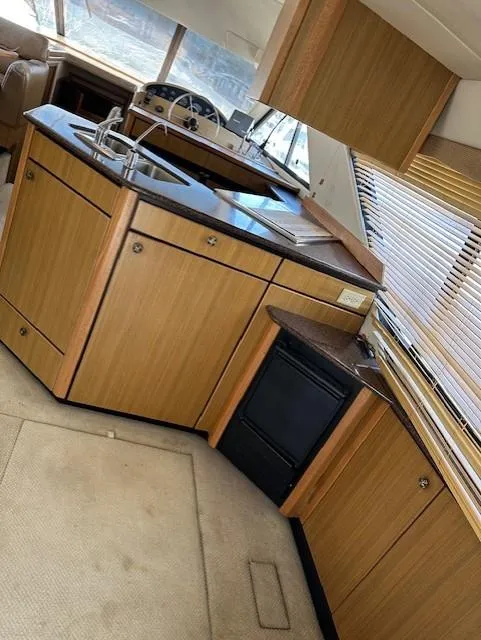 Slide: The Image of Interior of 2002 Bayliner 3988 Command Bridge Motoryacht with wooden cabinetry and compact kitchen. - 4