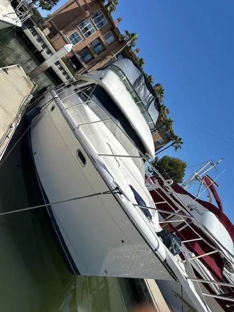 Slide: The Image of 2002 Bayliner 3988 Command Bridge Motoryacht docked at marina, clear blue sky. - 6