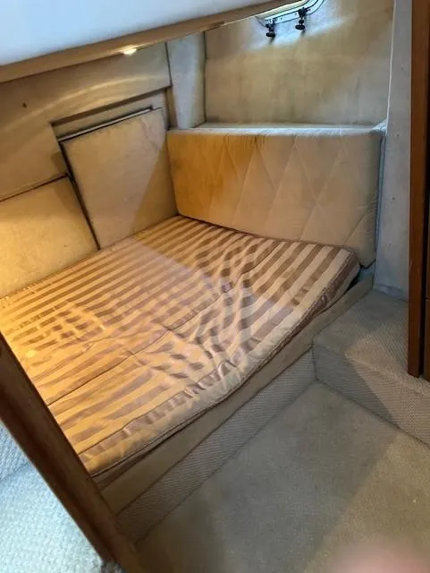 Slide: The Image of 2002 Bayliner 3988 Command Bridge Motoryacht cabin with striped bedding and cozy interior. - 8